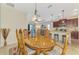 Dining room flows to the kitchen and living area, and includes seating for six and pendant lighting at 241 Marcheno Way, Nokomis, FL 34275