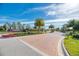 Milano community entrance with lush landscaping and brick-paved roundabout at 241 Marcheno Way, Nokomis, FL 34275