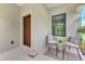 Inviting front porch with seating area near the entry door and window at 241 Marcheno Way, Nokomis, FL 34275