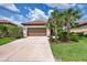 Charming single-story home with a two-car garage, terracotta roof, and mature landscaping at 241 Marcheno Way, Nokomis, FL 34275