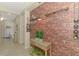 Hallway features faux brick accent wall, wine racks, console table and view of the living area at 241 Marcheno Way, Nokomis, FL 34275