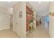 Hallway with a brick accent wall, leading to the dining area, with a view of the living space at 241 Marcheno Way, Nokomis, FL 34275