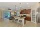 Modern kitchen with island seating, stainless appliances, and an open layout with lots of natural light at 241 Marcheno Way, Nokomis, FL 34275