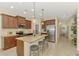 Kitchen features a granite island with seating, stainless steel appliances, and ample cabinet space at 241 Marcheno Way, Nokomis, FL 34275
