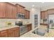Kitchen with stainless steel appliances, granite countertops, tile backsplash, and ample storage space at 241 Marcheno Way, Nokomis, FL 34275