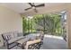 Outdoor lanai provides peaceful seating with a ceiling fan and scenic view of mature landscaping at 241 Marcheno Way, Nokomis, FL 34275