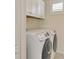 Laundry room showcases new washer and dryer and overhead cabinets for convenience and organized storage at 241 Marcheno Way, Nokomis, FL 34275