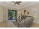 Bright living room showcases a ceiling fan, neutral color palette, and access to an outdoor patio at 241 Marcheno Way, Nokomis, FL 34275