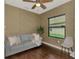 Cozy living room with modern ceiling fan, light blue sofa, and window providing natural light at 241 Marcheno Way, Nokomis, FL 34275