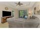 Comfortable living room featuring a large sofa, ceiling fan, and sliding glass doors to the lanai at 241 Marcheno Way, Nokomis, FL 34275