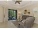 Cozy living room featuring a ceiling fan, comfortable seating, and sliding glass doors to the lanai at 241 Marcheno Way, Nokomis, FL 34275