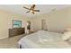 Bright main bedroom showcasing a queen size bed, dresser, and a view to the living room at 241 Marcheno Way, Nokomis, FL 34275