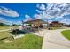 Outdoor park area with picnic tables, barbecue grill, and a covered shelter, set against a backdrop of a clear blue sky at 241 Marcheno Way, Nokomis, FL 34275