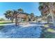 Picturesque picnic area nestled among palm trees, featuring shaded picnic tables and sandy ground for outdoor enjoyment at 241 Marcheno Way, Nokomis, FL 34275