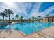 Community swimming pool with chairs and umbrellas, perfect for cooling off on a hot day at 241 Marcheno Way, Nokomis, FL 34275