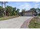 Charming single-story home featuring a wide driveway and attached two-car garage surrounded by mature trees at 2424 Affinity Ln, North Port, FL 34286