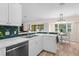 Bright kitchen with stainless steel appliances, white cabinets and peninsula countertop with an adjacent dining area at 2424 Affinity Ln, North Port, FL 34286