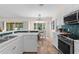 Bright kitchen featuring white cabinets, stainless steel appliances, peninsula countertop with view to dining area at 2424 Affinity Ln, North Port, FL 34286