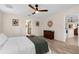 Bright and airy main bedroom with ceiling fan and view to the en-suite bath and kitchen at 2424 Affinity Ln, North Port, FL 34286