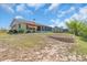Home's backyard with mature landscaping, retaining wall, and a view of the rear of the property at 2618 Titania Rd, Englewood, FL 34224