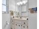 Well-lit bathroom with a white vanity, classic hardware, and a large mirror at 2618 Titania Rd, Englewood, FL 34224
