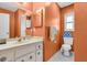 Bathroom with a white vanity, large mirror and stylish lighting at 2618 Titania Rd, Englewood, FL 34224