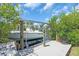 Image features a Key West boat on a lift, surrounded by lush vegetation and a wooden dock at 2618 Titania Rd, Englewood, FL 34224