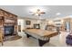 Inviting living room with a brick fireplace and a pool table perfect for entertaining at 2618 Titania Rd, Englewood, FL 34224