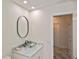 Bathroom vanity featuring a glass vessel sink, marble countertop, and oval mirror at 27416 Natal Dr, Punta Gorda, FL 33983