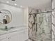 Elegant bathroom showcasing marble-style tiling, a modern glass vessel sink, and a glass shower at 27416 Natal Dr, Punta Gorda, FL 33983