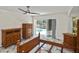 The primary bedroom features a ceiling fan, lanai access and a matching set of wooden furniture at 27416 Natal Dr, Punta Gorda, FL 33983