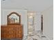 Bedroom with a beautiful wood dresser, mirror, and a peek at a spacious bathroom with marble floors at 27416 Natal Dr, Punta Gorda, FL 33983