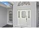 Close-up of the elegant white front door featuring decorative glass, sidelights, and stylish hardware, for added appeal at 27416 Natal Dr, Punta Gorda, FL 33983