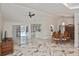 Bright living room with marble floors, ceiling fan, and sliding glass doors that offering views of the outdoor pool at 27416 Natal Dr, Punta Gorda, FL 33983
