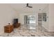 Bright living room featuring marble floors, ceiling fan, and sliding glass doors that lead to an outdoor pool area at 27416 Natal Dr, Punta Gorda, FL 33983