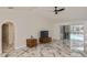 Bright living room featuring marble floors, ceiling fan, and sliding glass doors that lead to an outdoor pool area at 27416 Natal Dr, Punta Gorda, FL 33983