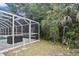 View of the pool enclosure with stone flooring and access to the surrounding yard at 27416 Natal Dr, Punta Gorda, FL 33983