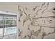 Shower with marble-look tile, integrated shelving, and pool access at 27416 Natal Dr, Punta Gorda, FL 33983