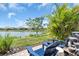 Landscaped backyard features a peaceful lake view and outdoor seating at 27467 Janzen Ct, Englewood, FL 34223