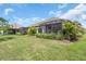 Expansive backyard features a lawn and screened-in patios for outdoor enjoyment at 27467 Janzen Ct, Englewood, FL 34223