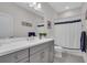 Grey vanity cabinets and grey tile floor in this stylish bathroom at 27467 Janzen Ct, Englewood, FL 34223