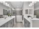 Beautiful dual vanities with grey cabinets and framed mirrors in this bathroom at 27467 Janzen Ct, Englewood, FL 34223