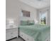 This bedroom features a large sunny window, ceiling fan and neutral walls at 27467 Janzen Ct, Englewood, FL 34223