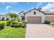 Charming home featuring a two-car garage, landscaped front yard with brick paved driveway, and lush greenery at 27467 Janzen Ct, Englewood, FL 34223