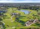 Scenic aerial shot of golf course with rolling greens, a tranquil pond, and mature trees at 27467 Janzen Ct, Englewood, FL 34223