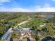 Aerial shot showcases the lush golf course, water features, and clubhouse under a clear blue sky at 27467 Janzen Ct, Englewood, FL 34223