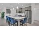 Modern kitchen with stainless appliances, gray cabinets, a large island, and stylish pendant lights at 27467 Janzen Ct, Englewood, FL 34223
