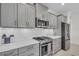Well-equipped kitchen with stainless steel appliances and sleek gray cabinetry at 27467 Janzen Ct, Englewood, FL 34223