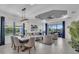 Open-concept living and dining room with modern light fixtures, patio access, and comfortable furniture at 27467 Janzen Ct, Englewood, FL 34223