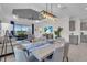 Open-concept living and dining room featuring stylish furnishings, a tray ceiling, and access to outdoor space at 27467 Janzen Ct, Englewood, FL 34223